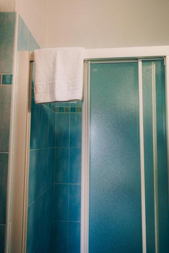 a shower with a towel hanging over a glass door at Hotel Enna Rimini in Rimini