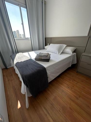a bed in a room with a large window at Laguna 380 - 1607B - Vista Palácio Tangará in São Paulo