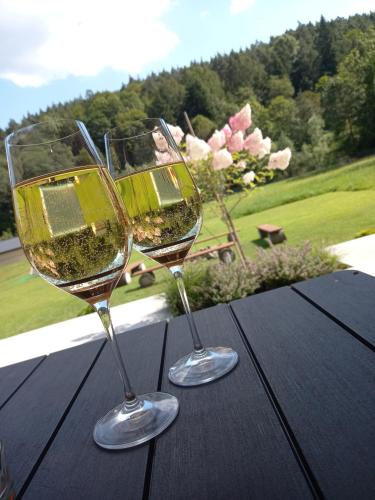 two glasses of wine sitting on a wooden table at MaGórka in Krempna