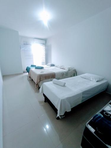 um quarto com três camas e uma janela em Apartamento Mobiliado no Centro Comercial em Imperatriz