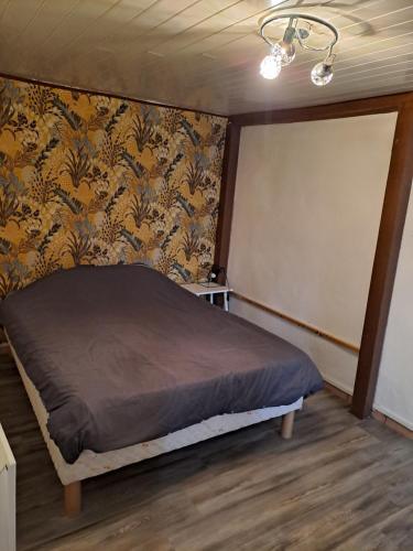 a bedroom with a bed in a room with wallpaper at Appartement de montagne in La Mure