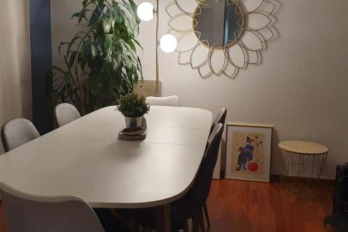 une table à manger blanche avec des chaises et une plante en pot dans l'établissement Appartement familial - Gentilly - Proche Paris 13, à Gentilly