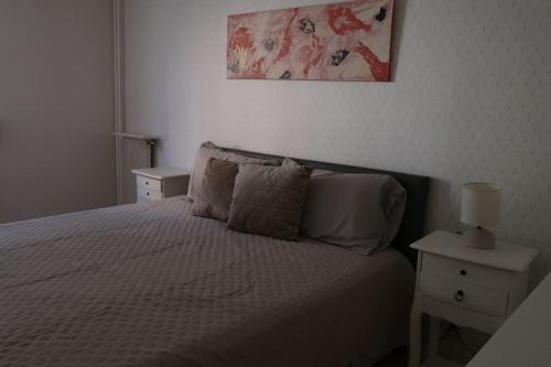 une chambre avec un lit blanc avec deux tables de nuit et publicité dans l'établissement Appartement familial - Gentilly - Proche Paris 13, à Gentilly