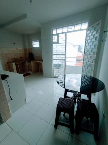 Zimmer mit einem Stuhl, einem Tisch und einem Fenster in der Unterkunft Apartamento Mobiliado no Centro Comercial in Imperatriz