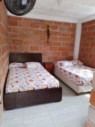 um quarto com 2 camas e uma parede de tijolos em La Clarita em San Rafael