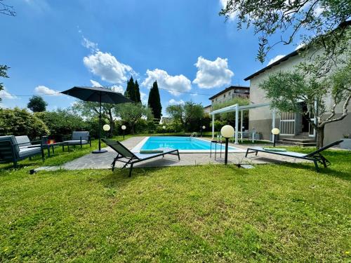 uma piscina com duas cadeiras e um guarda-sol em Casa 18 em Monzambano