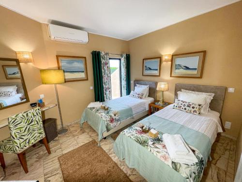a hotel room with two beds and a chair at Casa Canavial in Lagos