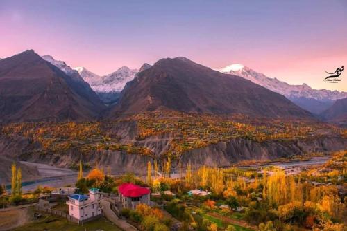 an aerial view of a mountain valley with a house and mountains at Interstellar by Old Hunza Inn in Hunza