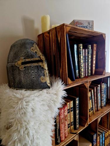 un sac à main posé sur une étagère avec des livres dans l'établissement Gîte atypique NormandiK, à Chailloué