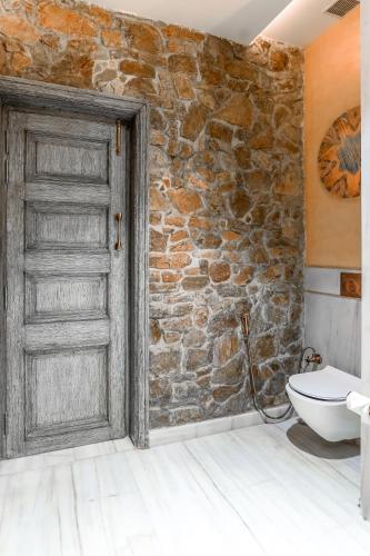 an open door in a bathroom with a stone wall at Juna Mahal Jungle Resort Ranthambore in Sawāi Mādhopur