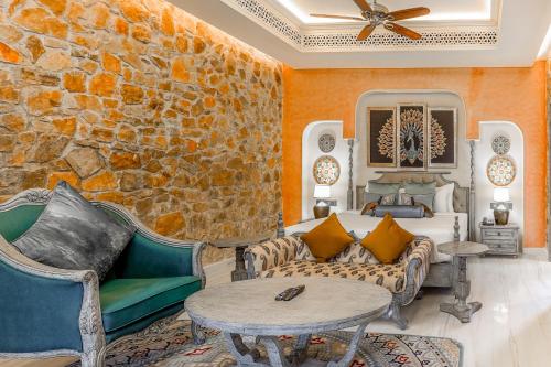 a living room with a couch and a stone wall at Juna Mahal Jungle Resort Ranthambore in Sawāi Mādhopur