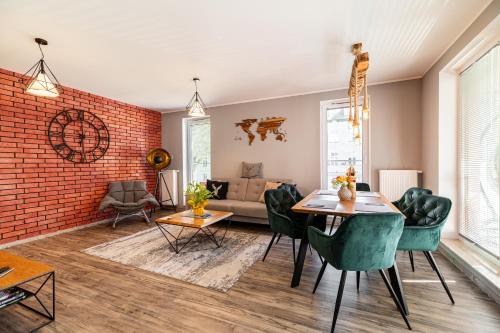 a living room with a brick wall and a table and chairs at LIKE APARTMENT in Kołobrzeg