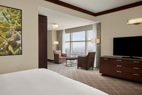 a hotel room with a bed and a flat screen tv at Doubletree By Hilton Jabal Omar Makkah in Makkah