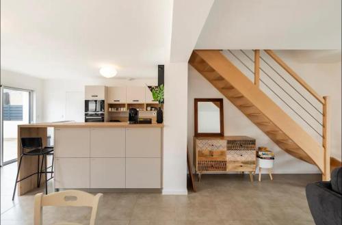 une cuisine avec des placards blancs et un escalier dans l'établissement La villa Hérault, à Cholet