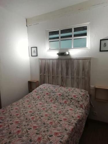 - une chambre avec un lit doté d'un couvre-lit floral et d'une fenêtre dans l'établissement Appartement de charme avec vue panoramique 4 pers, à Béziers