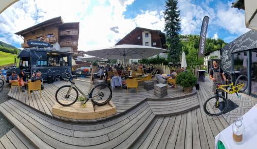 rower zaparkowany na drewnianym tarasie obok restauracji w obiekcie SKILL Mountain Lodge - Ski und Bike Hostel im Sommer mit JOKER CARD w Saalbach Hinterglemm