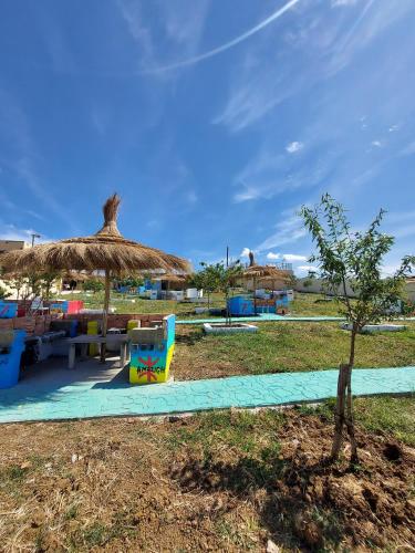 a beach with a straw umbrella and a table and chairs at LA GRANJA in Tetouan
