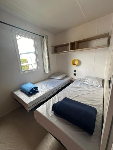 deux lits dans une petite pièce avec une fenêtre dans l'établissement Camping le Moulin de la Salle, à Les Sables-dʼOlonne