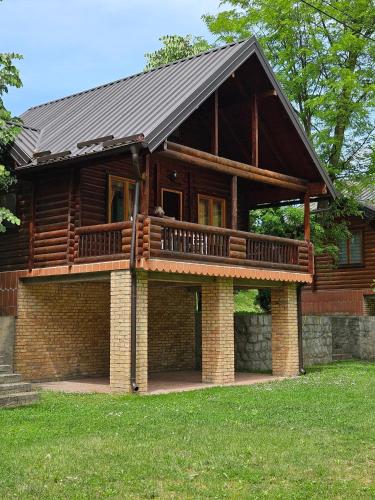 a log cabin with a porch and a deck at Drinski Maldivi 2 in Vrhpolje