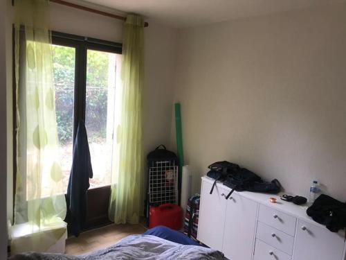 - une chambre avec un lit, une fenêtre et une commode dans l'établissement Appartement proche plage, à La Londe-les-Maures