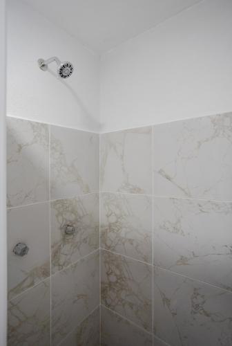 a bathroom with a shower with marble tiles at Hotel El Rincón in San Francisco del Rincón