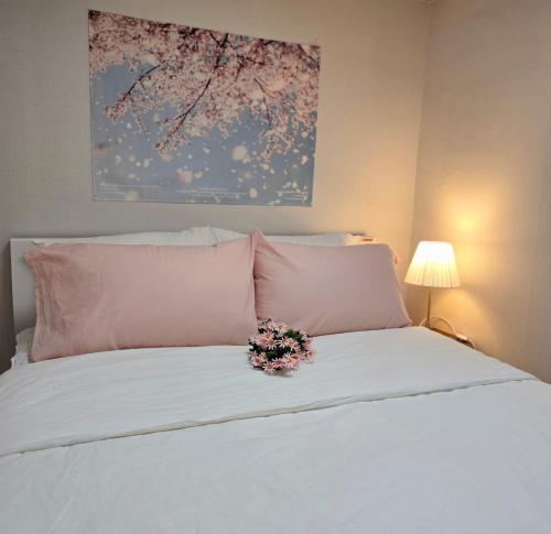 Un dormitorio con una cama con un arreglo floral encima. en Kozy Stay,신당역도보4분,동대문,ddp,명동,홍대,경복궁,서울타워,종로,강남,이태원,잠실,K-pop, en Seúl
