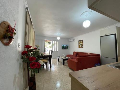 ein Wohnzimmer mit einem roten Sofa und einem Tisch in der Unterkunft Isufi House in Delvinë