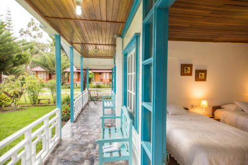 奧克薩潘帕的住宿－Cemayu Lodge，门廊上的卧室配有一张床
