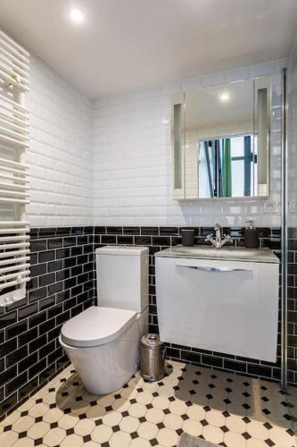 une salle de bain avec toilettes, lavabo et miroir dans l'établissement Casa Blanca, à Paris