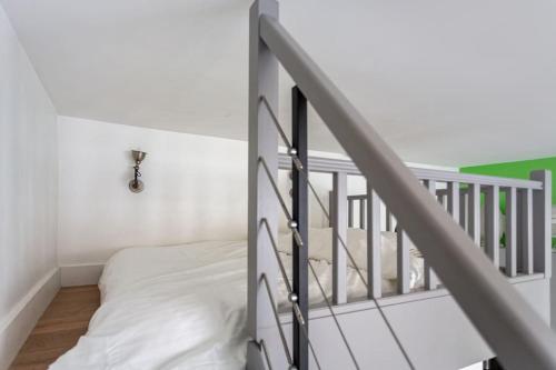 - une chambre blanche avec un lit et un escalier dans l'établissement Casa Blanca, à Paris