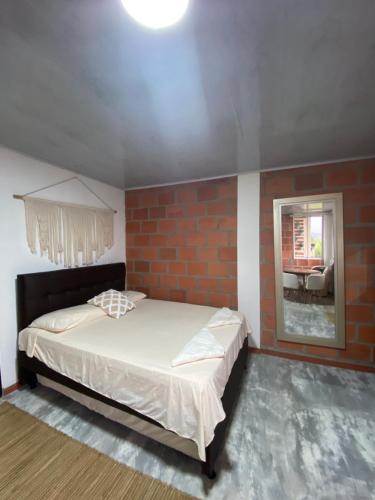1 dormitorio con cama y pared de ladrillo en Green Apartment el prado, en Girón