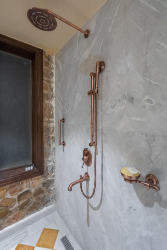 a shower in a bathroom with a stone wall at Juna Mahal Jungle Resort Ranthambore in Sawāi Mādhopur