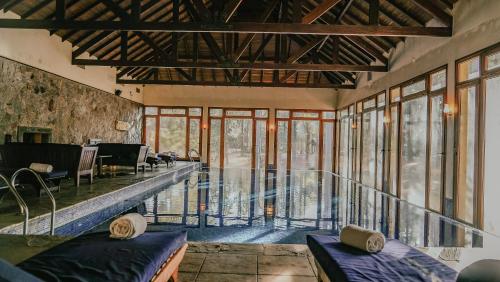 a large room with a swimming pool and windows at Carmelo Resort & Spa in Carmelo