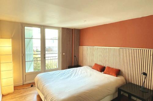 a bedroom with a large bed and a window at Maison proche du centre de Paris calme et verdure in Villejuif