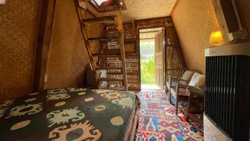 a small room with a bed and a staircase at Monsonkeang Camping view ม่อนสันเกี๋ยง in Mae Chaem