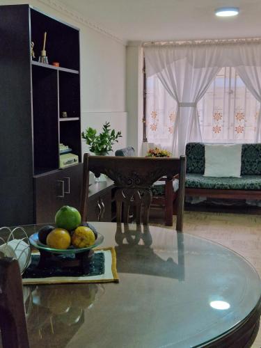 a living room with a table with a bowl of fruit at Habitaciones en Edificio Ginebra Manizales in La Linda