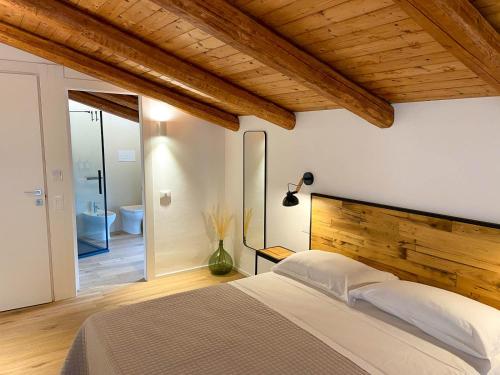 a bedroom with a large bed and a bathroom at La Piazzetta in Morigerati