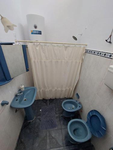 bagno con servizi igienici blu e lavandino di Casa Amandus a Trinidad