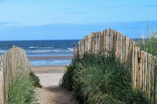 a wooden fence on a beach near the ocean at Central St Andrews 2 bed apartment in St Andrews