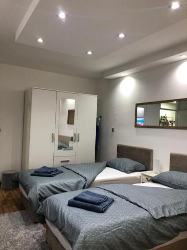 a bedroom with three beds and a mirror at Welcome to the Apartment Mesic- Airport Sarajevo in Sarajevo