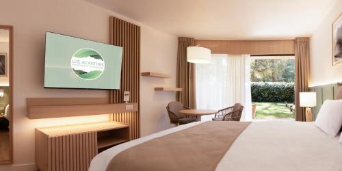 a hotel room with a bed and a tv at Résidence Hôtelière les Acanthes in Hossegor