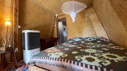 um quarto com uma cama com um cobertor estampado em Monsonkeang Camping view ม่อนสันเกี๋ยง em Mae Chaem