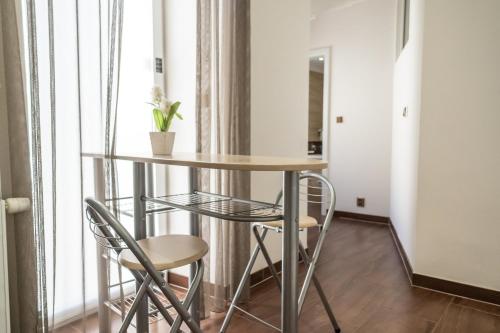 a table and chairs in a room with a window at Hotel Plzeň in Plzeň