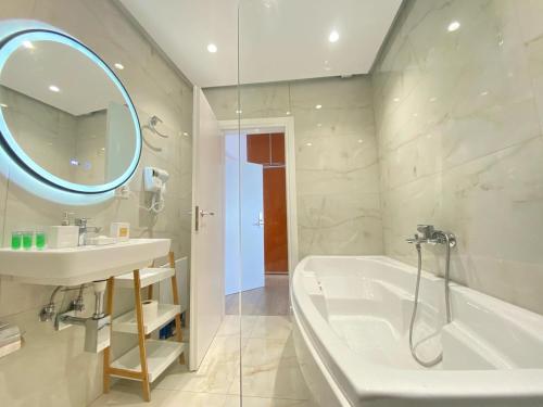 a bathroom with a sink and a tub and a mirror at comfort rooms in Himare