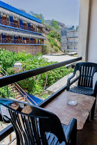 a table and chairs on a balcony with a view at Hotel Manava in Brisas de Zicatela