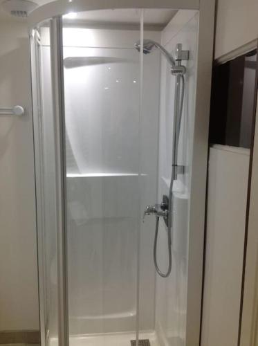 une douche avec une porte vitrée dans une salle de bain dans l'établissement La parenthèse à la campagne, à La Canourgue