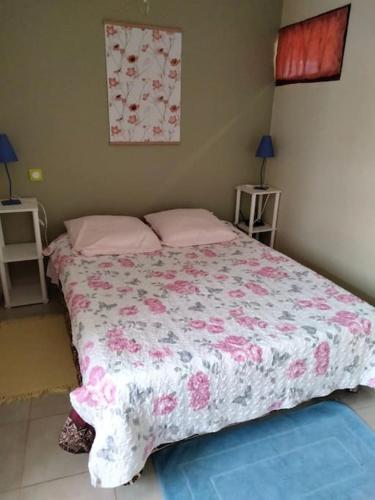 - une chambre dotée d'un lit avec une couverture rose et blanche dans l'établissement La parenthèse à la campagne, à La Canourgue