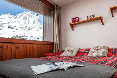ein Schlafzimmer mit einem Buch und einer Brille auf dem Bett in der Unterkunft Marcolski home in Breuil-Cervinia