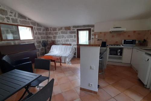 une cuisine et un salon avec une table et des chaises dans l'établissement Bergerie en pierres et oliveraie, à Porto-Vecchio