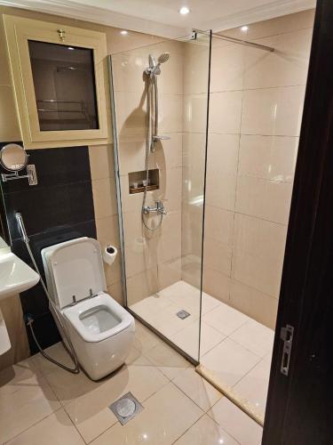 a bathroom with a shower with a toilet and a sink at East Diamond Serviced Apartments in Jeddah